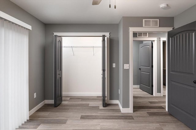 unfurnished bedroom featuring a closet, hardwood / wood-style flooring, and ceiling fan