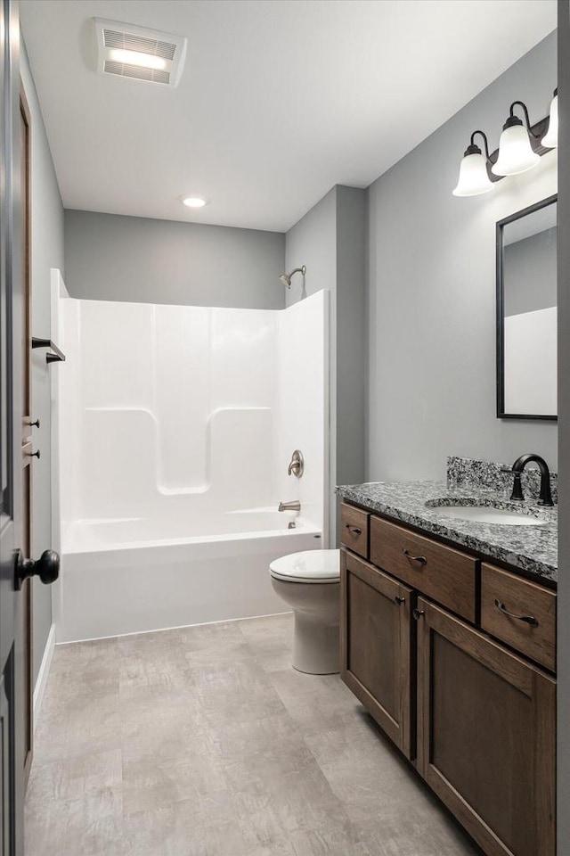 full bathroom featuring vanity, washtub / shower combination, and toilet