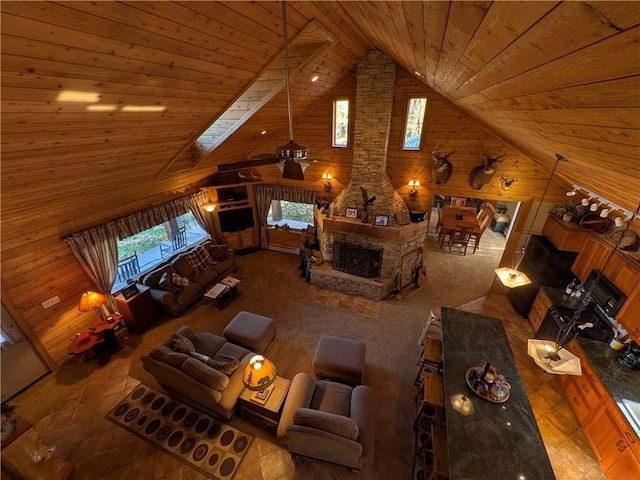 interior space featuring wood ceiling, lofted ceiling with skylight, wooden walls, and ceiling fan