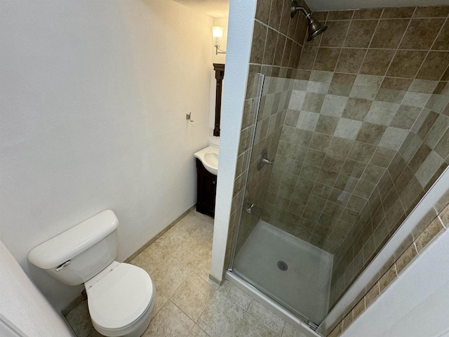 bathroom featuring toilet, vanity, and a shower with door