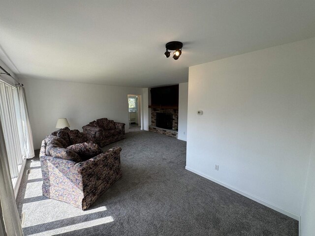 unfurnished living room with dark colored carpet and a fireplace