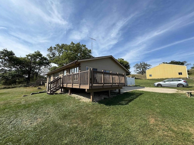 rear view of property featuring a deck and a lawn