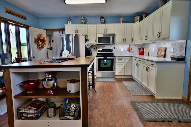 kitchen featuring appliances with stainless steel finishes, decorative backsplash, white cabinetry, and dark hardwood / wood-style flooring