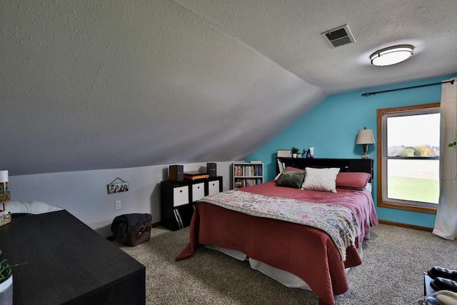 bedroom featuring a textured ceiling, vaulted ceiling, and light colored carpet