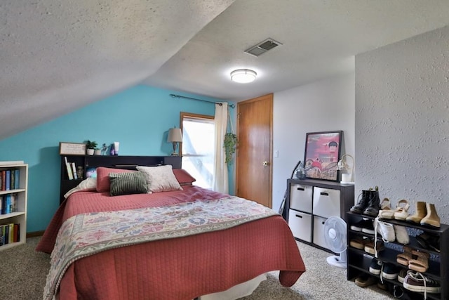 carpeted bedroom featuring a textured ceiling and lofted ceiling