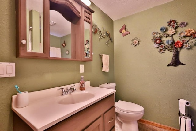 bathroom featuring vanity, a textured ceiling, and toilet