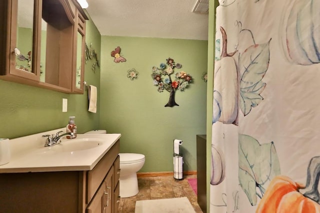 bathroom featuring vanity, toilet, and a textured ceiling