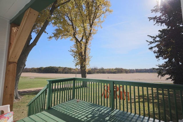 wooden terrace with a yard and a rural view