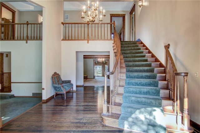 stairs featuring an inviting chandelier and hardwood / wood-style flooring