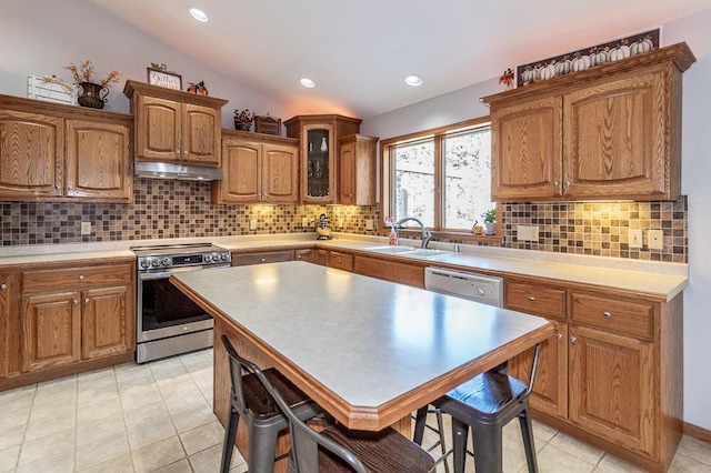 kitchen featuring stainless steel electric stove, lofted ceiling, backsplash, a kitchen bar, and sink