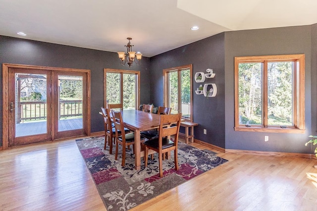 dining space featuring a chandelier, light wood-type flooring, and a healthy amount of sunlight