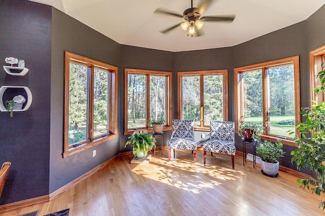 unfurnished sunroom with ceiling fan and a wealth of natural light