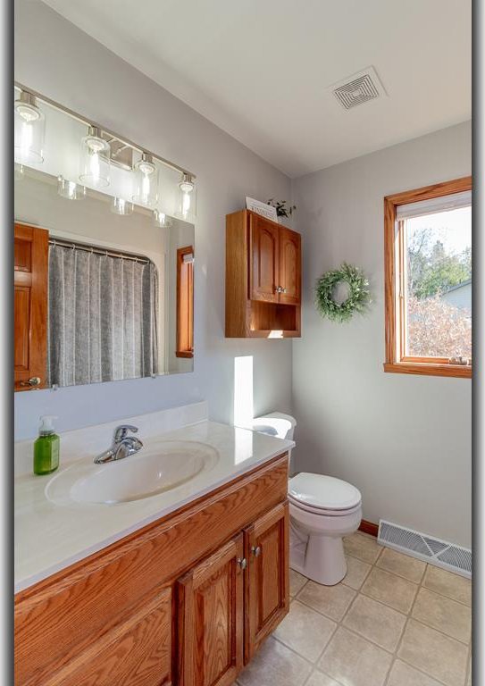 bathroom featuring vanity, toilet, and tile patterned flooring