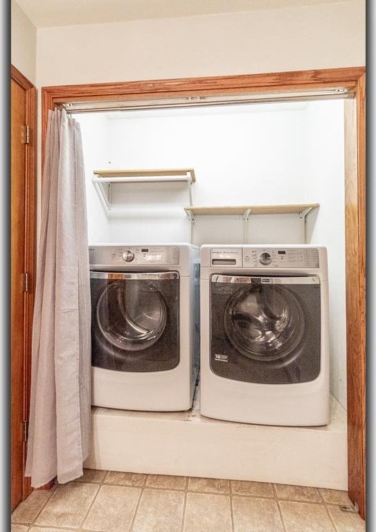 laundry room with light tile patterned flooring and washing machine and dryer