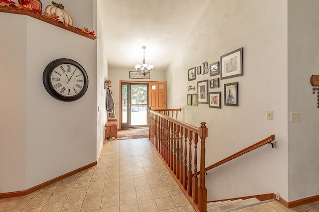 hallway featuring light tile patterned floors, lofted ceiling, and a chandelier