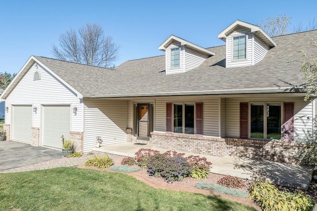 cape cod home featuring a front lawn, covered porch, and a garage