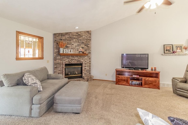 living room featuring ceiling fan, vaulted ceiling, a brick fireplace, and light colored carpet