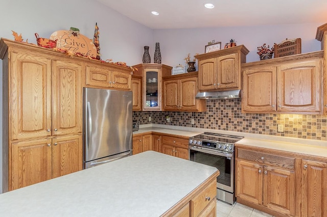 kitchen featuring decorative backsplash, stainless steel appliances, light tile patterned floors, and vaulted ceiling