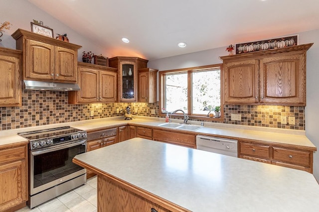 kitchen with lofted ceiling, tasteful backsplash, white dishwasher, stainless steel range, and sink