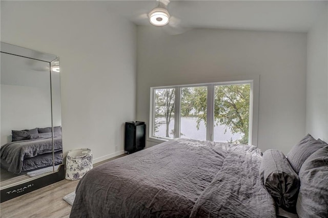 bedroom featuring hardwood / wood-style flooring, high vaulted ceiling, and ceiling fan