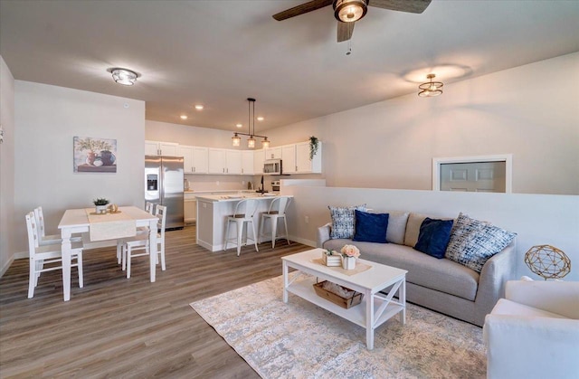 living room with light wood-type flooring and ceiling fan