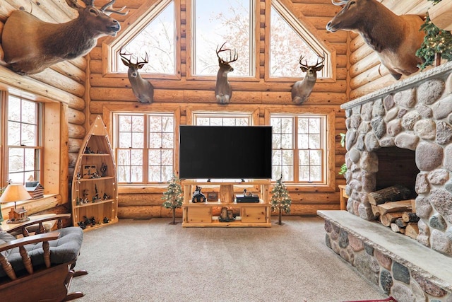 carpeted living room featuring a wealth of natural light, a stone fireplace, and log walls