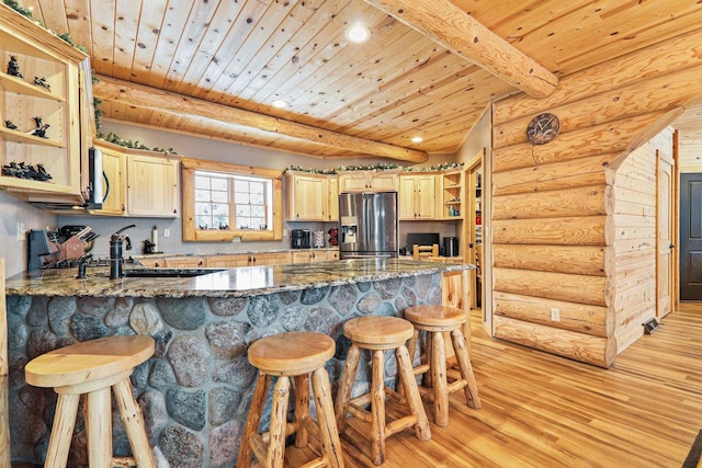 kitchen featuring light hardwood / wood-style flooring, light brown cabinets, dark stone countertops, and stainless steel fridge with ice dispenser