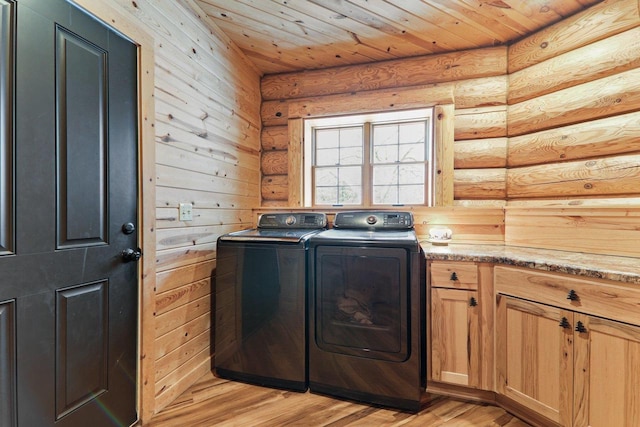 laundry area featuring wooden ceiling, washing machine and dryer, cabinets, and light wood-type flooring