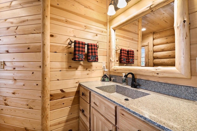 bathroom with vanity and log walls