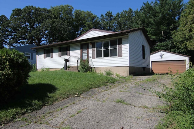 view of front of home with a garage, a front lawn, and an outbuilding