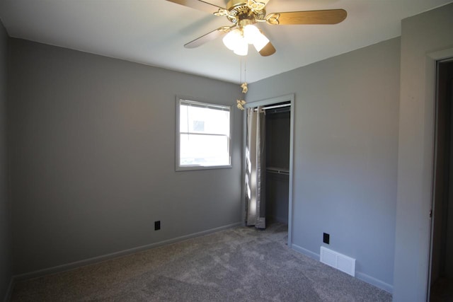 unfurnished room featuring ceiling fan and dark colored carpet