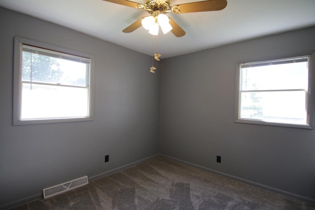 carpeted spare room with a healthy amount of sunlight and ceiling fan