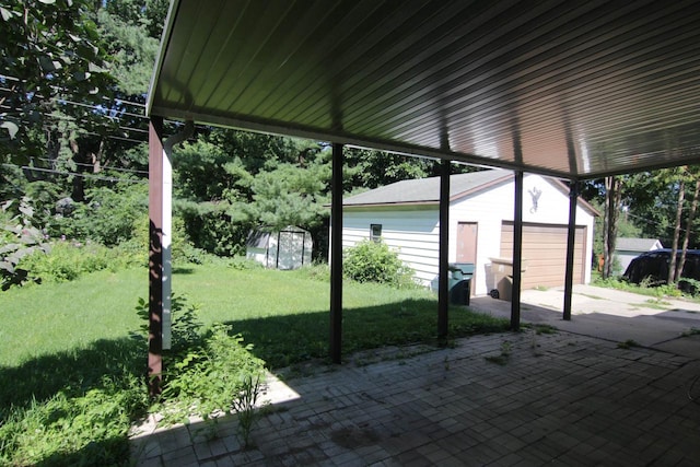 view of patio / terrace with a storage shed and a garage