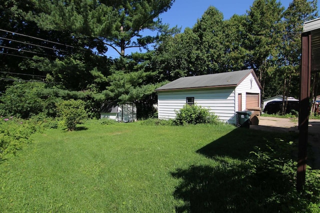 view of yard featuring a storage shed and a garage