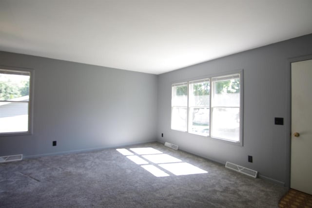 unfurnished room featuring dark colored carpet