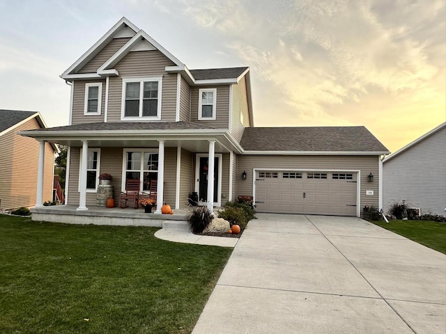 view of front facade with covered porch, a lawn, and a garage