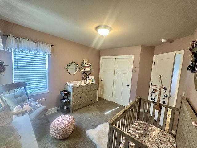 bedroom with a closet, dark carpet, and a nursery area