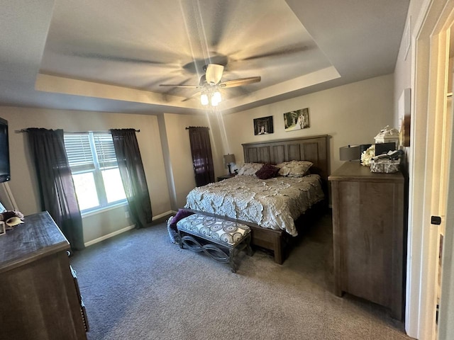 bedroom featuring carpet flooring, a tray ceiling, and ceiling fan