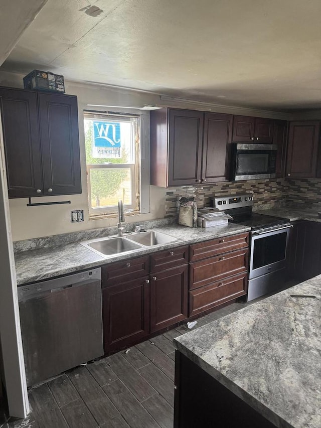 kitchen featuring tasteful backsplash, stainless steel appliances, dark brown cabinets, sink, and dark wood-type flooring