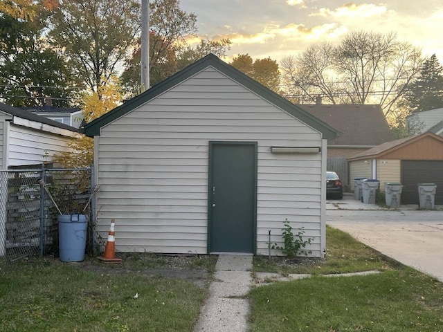 outdoor structure at dusk featuring a lawn and a garage