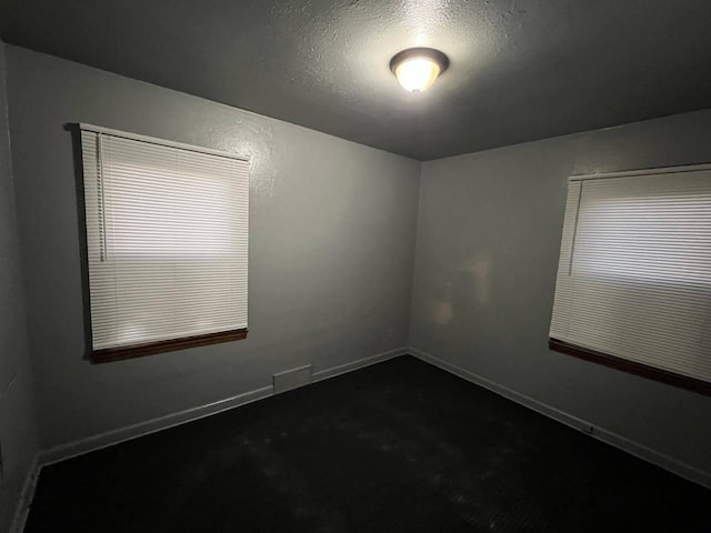 carpeted spare room featuring a textured ceiling