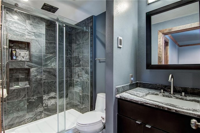 bathroom featuring vanity, toilet, and walk in shower