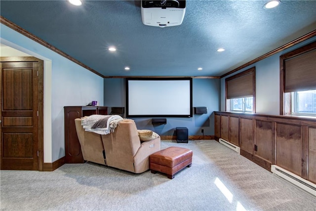 cinema with crown molding, a baseboard heating unit, and light colored carpet