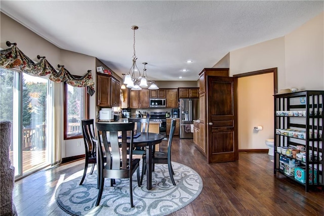 dining area with dark wood-type flooring and a chandelier