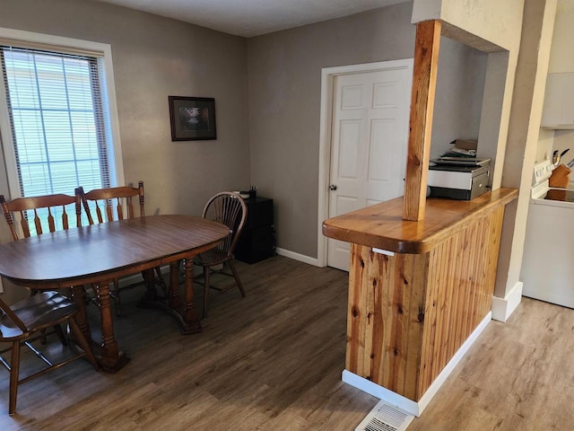 dining area featuring wood-type flooring and washer / dryer