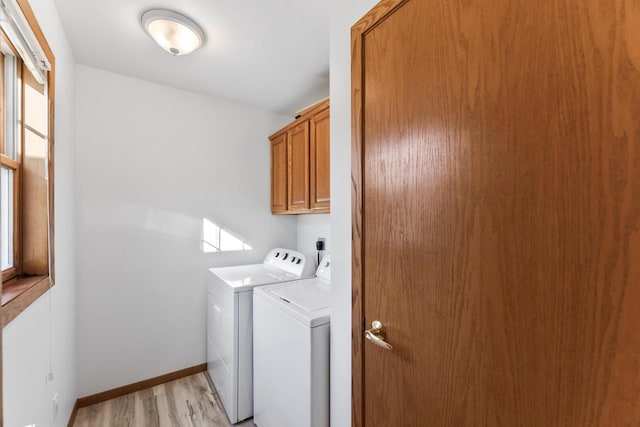 laundry room with cabinets, washer and clothes dryer, and light hardwood / wood-style floors