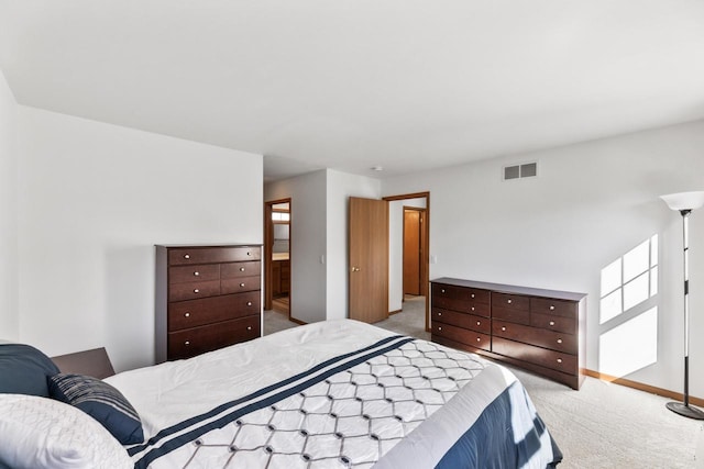 bedroom with light colored carpet and ensuite bath