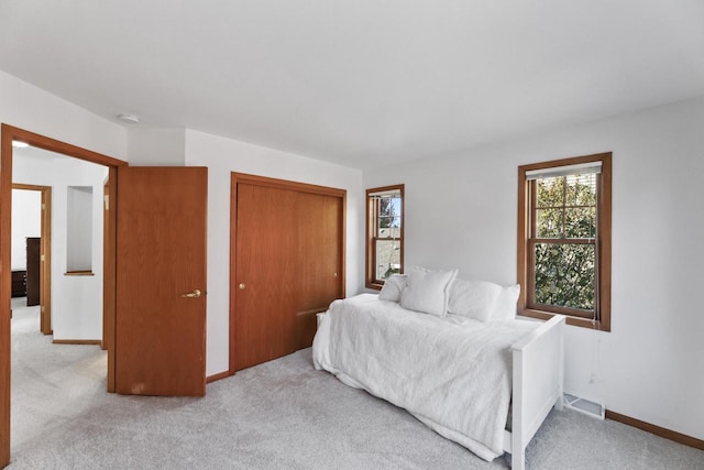 bedroom featuring a closet and light colored carpet