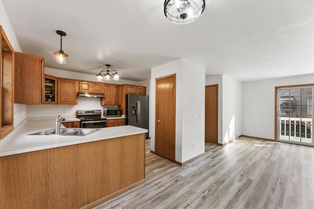 kitchen with light hardwood / wood-style flooring, hanging light fixtures, stainless steel appliances, kitchen peninsula, and sink