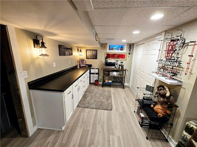 bar featuring white cabinetry and light wood-type flooring